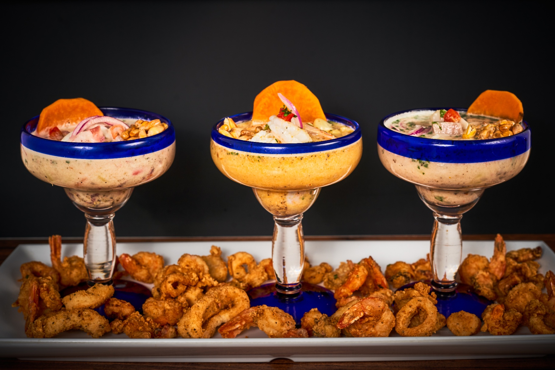 Three ceviche cups served over crispy seafood